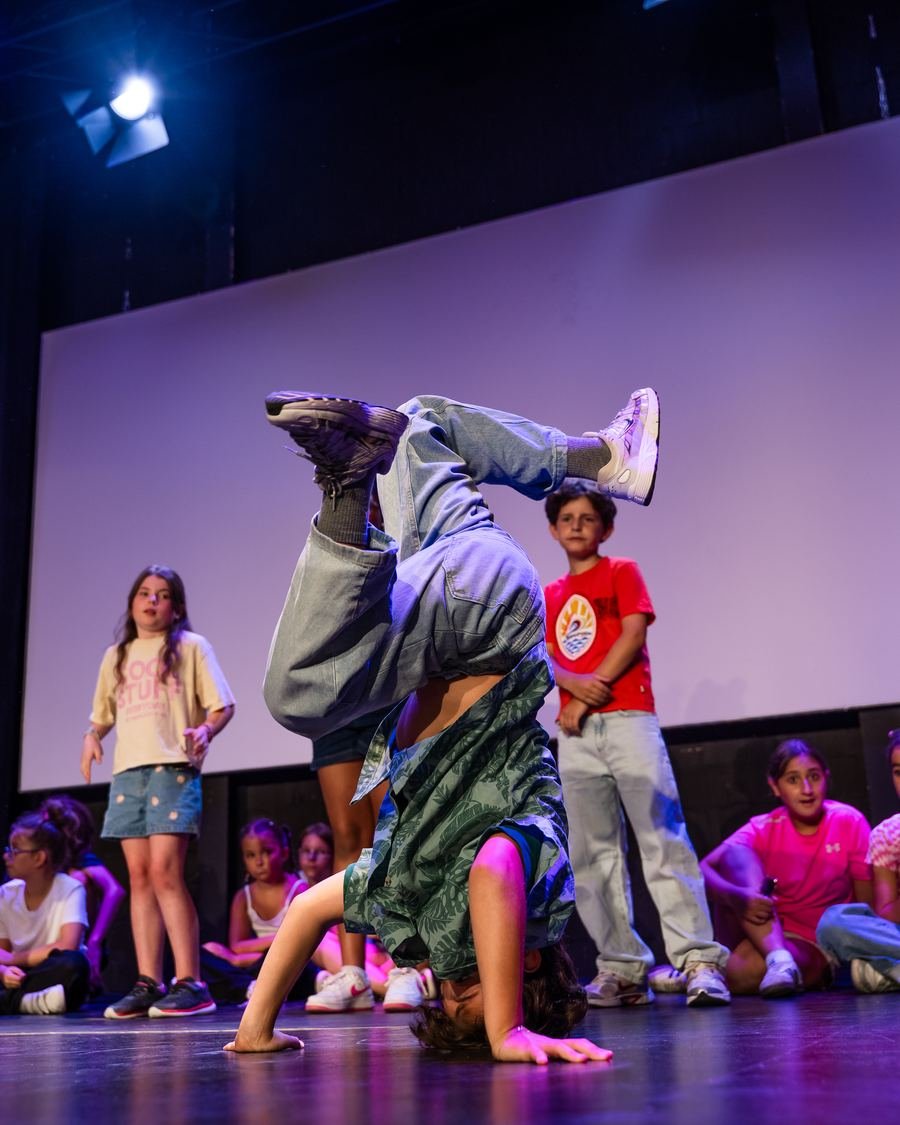 Enfant en pleine figure de breakdance sur scène, gala enfants Studio 116
